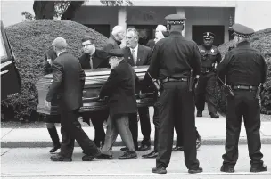  ??  ?? Pittsburgh police stand guard as pallbearer­s carry the casket of Irving Younger, 69, from Congregati­on Rodef Shalom after his funeral Wednesday. Younger was one of the 11 victims killed Saturday in the deadly shooting at a synagogue in Pittsburgh’s Squirrel Hill neighborho­od.