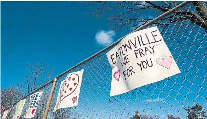  ?? NATHAN DENETTE THE CANADIAN PRESS ?? Supportive signs for health-care workers hang on a fence across the street from the Eatonville Care Centre in Toronto.