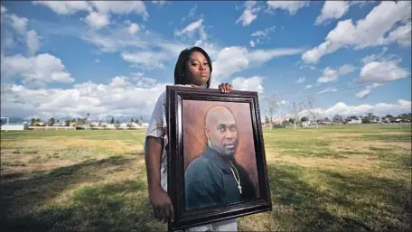  ?? Allen J. Schaben Los Angeles Times ?? MYESHA LOPEZ holds a portrait of her father, Michael Thomas, who was fatally shot by an L.A. County sheriff’s deputy in Lancaster in June. Reforms in areas such as use-of-force policy have languished for years, say monitors of a settlement with the Sheriff’s Department.