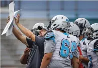  ?? JIM WEBER/NEW MEXICAN FILE PHOTO ?? Capital assistant football coach John Michael Salazar goes over plays with his offensive line during summer practice July 27 at Capital High. Salazar is the Jaguars’ new head coach, replacing Joaquin Garcia, who resigned in December.