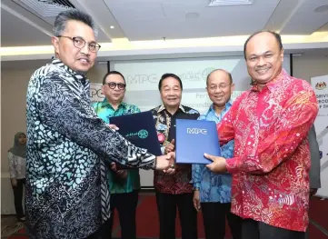  ??  ?? Mohd Shibli (left) and Tengku Azmi exchange documents. From second left are Abang Karim, Wong, and Azman.