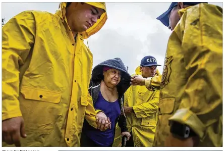  ??  ?? Above: Firefighte­rs help Guadalupe Guerra walk to a bus headed for San Antonio at an evacuation center in Corpus Christi on Friday. Hundreds of Corpus Christi-area residents boarded buses Friday morning to be transporte­d to a shelter in San Antonio....