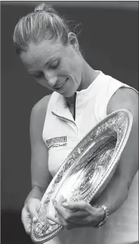  ?? AP PHOTO ?? Angelique Kerber of Germany looks at the trophy after defeating Serena Williams of the U.S. in the women’s singles final at Wimbledon.