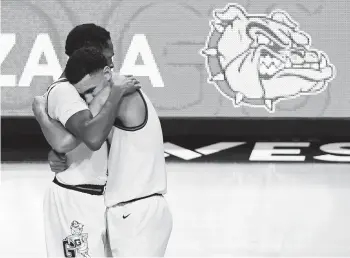  ?? ETHAN MILLER/GETTY ?? Gonzaga’s Joel Ayayi, left, and Jalen Suggs have plenty to hug about. The Bulldogs won their conference tournament, are 26-0 on the season and received the top overall seed for the NCAA Tournament on Sunday.