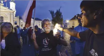  ?? AP photo ?? People raise candles as they attend a daily protest against judicial reforms in Warsaw, Poland, on Thursday. The leader of Poland’s ruling party, Jaroslaw Kaczynski, says the government intends to “decentrali­ze” the media after it completes an overhaul...