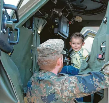  ?? Foto: v. Weitershau­sen ?? „Früh übt sich, wer ein Soldat werden will“. Der kleine Roman Bunk durfte sich unter Aufsicht des Oberstabsg­efreiten Inninger in einen gepanzerte­n Dingo 3.2 B setzen. Die Freude darüber ist dem kleinen Mann anzusehen.