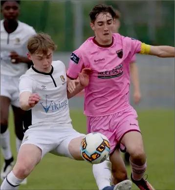  ??  ?? Hat-trick hero Evan Farrell putting pressure on Cormac Doyle of Waterford F.C.