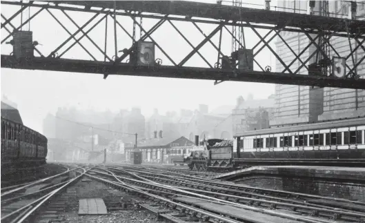  ?? V R Webster Collection/Kiddermins­ter Railway Museum ?? The Princes Street station site changed much over the years, with three different stations and the operationa­l changes that brought about, but also changes to the wider site, with the clearance of land when expansion was needed. We are looking out from the end of the trainshed towards Morrison Street as a Caledonian 2-4-0 departs the station. With inclined cylinders this appears to be a Conner era double-frame ‘Crewe’ type with a curved running plate, cut-outs in the outside frames, and a stovepipe chimney. Such engines dated from 1858/59 but were rejuvenate­d at rebuilding and served through to 1894-1902. Note the signal gantry, its shadow across the platform end giving away its siting at the time. A row of branch line coaching stock is just in view to the left, and the monolithic building on the right is perhaps the south wing of the Edinburgh Lighting Central Generating Station that dates from 1898, although this particular building appears to have been short-lived.