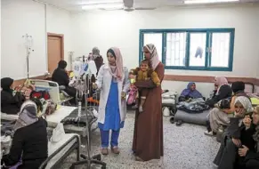  ?? ?? Palestinia­n women and infants displaced from northern Gaza receive medical care at a clinic in rafah.