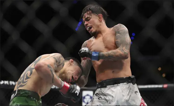  ?? LUIS MARIN — EYEPIX GROUP VIA AP ?? Brandon Royval from the United States is punching Brandon Moreno of Mexico in a flyweight fight during the UFC Fight Night event at CDMX Arena in Mexico City on Saturday.