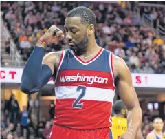  ?? AFP ?? John Wall of the Wizards flexes his muscles after scoring against the Cavaliers.