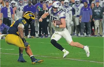  ?? AP PHOTO/RICK SCUTERI ?? TCU quarterbac­k Max Duggan tries to get past Michigan linebacker Junior Colson during the Fiesta Bowl, a College Football Playoff semifinal, last Saturday in Glendale, Ariz.