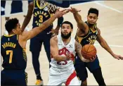  ?? Associated Press photo ?? Toronto Raptors guard Fred VanVleet (23) goes under Indiana Pacers guards Malcolm Brogdon (7) and Jeremy Lamb (26) to shoot during the second half of an NBA basketball game in Indianapol­is, Monday.