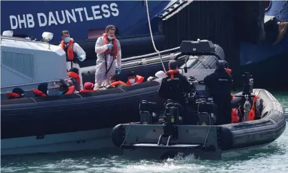  ?? Photograph: Paul Childs/Reuters ?? People sit in a Border Force boat after arriving at Dover harbour on Sunday.