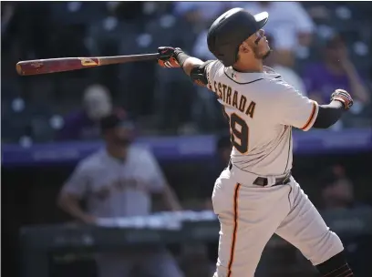  ?? PHOTOS BY DAVID ZALUBOWSKI — THE ASSOCIATED PRESS ?? The Giants’ Thairo Estrada follows the flight of his two-run home run off Colorado Rockies starting pitcher Kyle Freeland in the fifth inning Monday afternoon in Denver.