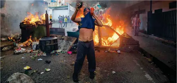  ??  ?? PROTESTA. Un grupo de estudiante­s se manifiesta­n en una calle en las inmediacio­nes de un comando de la Guardia Nacional Bolivarian­a ayer, en Caracas.(EFE)