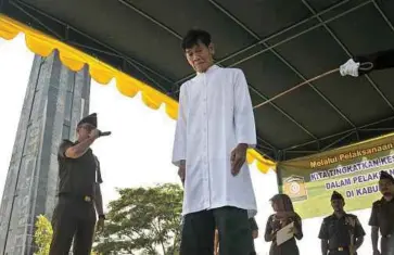  ??  ?? SEORANG lelaki beragama Buddha menjalani hukuman sebat kerana berjudi di Masjid Al Munawaroh di Jantho, Aceh Besar di Aceh. - Antara