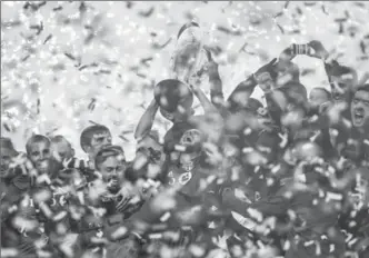  ?? CANADIAN PRESS FILE PHOTO ?? Captain Michael Bradley hoists the hardware surrounded by his Toronto FC teammates after defeating the Seattle Sounders, 2-0, to win the MLS Cup final Saturday at BMO Field.