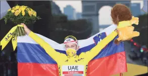  ?? Stephane Mantey / Associated Press ?? Tour de France winner Slovenia’s Tadej Pogacar, celebrates with his national flag on the podium on Sunday.