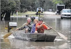  ?? JERRY LARSON / WACO TRIBUNE HERALD ?? J.B. Neckar (right) and his brother, Johnny Neckar, paddle their mother, Gelene Neckar, from her flooded home near Downsville on Saturday. Heavy rains forced parts of the Brazos River to overflow its banks and endanger homes in the small community...