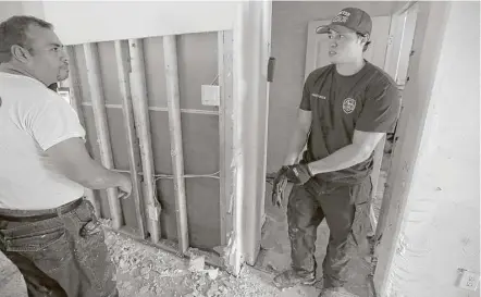  ?? Melissa Phillip / Houston Chronicle ?? Jesse Morales, left, helps his son, Jordan, clean up his home in Spring. The younger Morales does not have flood insurance.