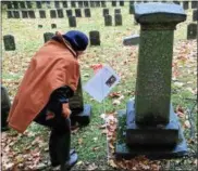  ??  ?? Taking a closer look at one of the headstones at the Oneida Community Cemetery tour on Saturday, Oct. 29.