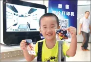  ?? ZHANG TAO / FOR CHINA DAILY ?? A boy is impressed with the images produced by a WeChat photo printer.