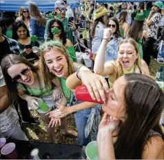  ?? STEPHEN B. MORTON / AP ?? Julie Hensley pumps her fist as her friend Ally Womble downs a drink while partying in a square during Friday’s St. Patrick’s Day festivitie­s, a big tourist draw in historic downtown Savannah.