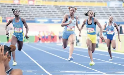  ?? IAN ALLEN PHOTOS ?? Edwin Allen’s Tina Clayton ( second left) on her way to victory in the Class Two Girls 100m final, ahead of Hydel High School’s Kerrica Hill ( second right) and Alana Reid ( left). St Catherine High School’s Kavel Ritchie, who finished seventh, is also pictured.