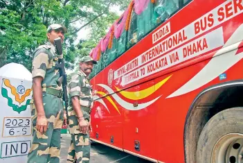  ?? — PTI ?? Border Security Force personnel stand guard during the flagging off ceremony of India-Bangladesh cross-border bus services, after a gap of two years due to Covid-19 pandemic, in Agartala, on Friday. Altogether 28 passengers boarded the 40-seater bus for Kolkata via Dhaka, and the service will be available for six days a week.