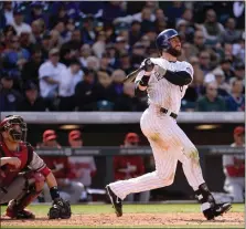  ?? HYOUNG CHANG — THE DENVER POST ?? Rockies outfielder Charlie Blackmon hits a two-run home run in the fourth inning against the Diamondbac­ks at Coors Field in Denver on April 4, 2014.