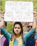  ??  ?? A journalist holds a placard during a protest near the parliament over the murder of journalist­s in New Delhi on Tuesday. — AFP