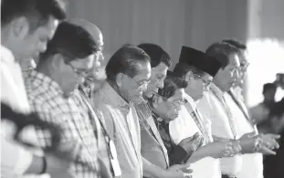  ??  ?? PRAYER FOR PEACE — President Duterte bows in prayer during the Bangsamoro Assembly held at the Old Provincial Capital in Sultan Kudarat, Maguindana­o last Monday. Also in photo are Presidenti­al Adviser on the Peace Process Jesus Dureza and Bangsamoro...