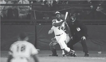  ?? HARRY HARRIS/AP ?? Hank Aaron watches home run No. 715 sail over the outfield wall at Atlanta-Fulton County Stadium on April 8, 1974, breaking the career record held by Babe Ruth. Aaron’s pursuit of Ruth’s record drew death threats.