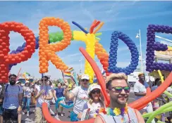  ??  ?? Allan Ibarra, front, walks with a group of Comcast employees during Saturday’s Albuquerqu­e Pride Parade on Central Avenue.