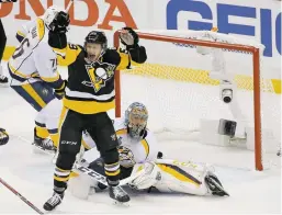  ?? GENE J. PUSKAR THE ASSOCIATED PRESS ?? The Penguins’ Jake Guentzel celebrates a goal by Evgeni Malkin in front of Predators goalie Pekka Rinne Monday during Game 1 of the Stanley Cup Final in Pittsburgh. Guentzel later scored the go-ahead goal with 3:17 left in regulation, helping the...