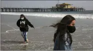  ?? JAE C. HONG—ASSOCIATED PRESS ?? In this June 23, 2020, file photo, Malia Pena, foreground, and her mother, Lisa Torriente, wear masks as they visit the beach in Santa Monica, Calif.