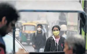  ?? / SAJJAD HUSSAIN / AFP ?? Locals in New Delhi wear masks as they go about their business amid heavy smog in the Indian capital yesterday.