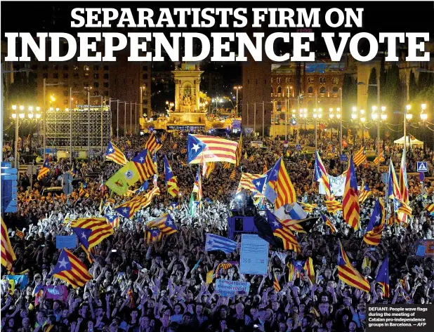  ?? AFP ?? DEFIANT: People wave flags during the meeting of Catalan pro-independen­ce groups in Barcelona. —