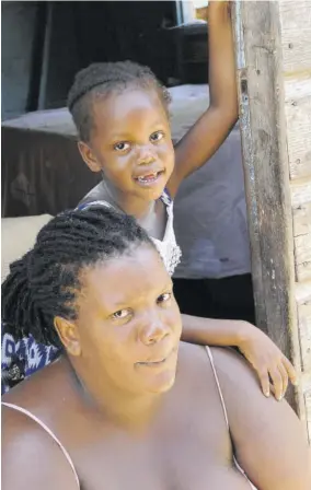  ?? (Photos: Garfield Robinson) ?? Kay-ann Taylor and daughter Adrianna Collins sit by the steps of their two-bedroom dwelling in New Market Oval, Savanna-la-mar, Westmorela­nd.