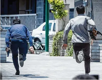  ?? Foto: Tasnim, dpa ?? Bewaffnete Männer laufen zum Parlament in Teheran. Dieses Gebäude sowie das Mausoleum des verstorben­en Revolution­sfüh rers Ajatollah Ruhollah Chomeini sind zuvor gestürmt worden.