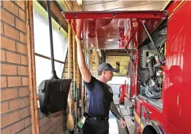  ?? BILL LACKEY PHOTOS / STAFF ?? Springfiel­d firefighte­rs have to be careful when opening the doors on the fire engine because the garage bay is so small Thursday.