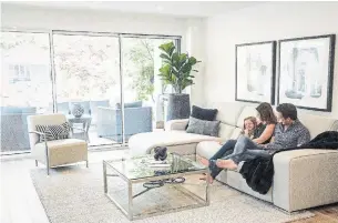  ?? ANDREW LAHODYNSKY­J FOR THE TORONTO STAR ?? NOW: Matthew and Melissa Kilkenny, with daughter Emma, in their updated living room that’s now flooded with natural light from a new, wall-to-wall sliding window.