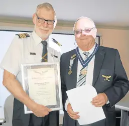  ??  ?? TOKEN OF APPRECIATI­ON: Des Lynch, left, was awarded a merit of appreciati­on for all he does to promote and preserve ideas of the South African Air Force Associatio­n as presented by chairman of the local branch Hugh Holmes
