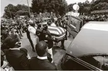  ??  ?? Members of the armed forces transfer Lewis’ body to a hearse after his final crossing of the Edmund Pettus Bridge.