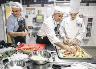  ?? PHOTOS BY BRUCE R. BENNETT / THE PALM BEACH POST ?? Members of team Avossa — the school district’s director of Choice and Career Options Pete Licata (from left), Superinten­dent Robert Avossa and senior David Izzo — prepare their dishes Friday during the Chopped Mystery Box event at William T. Dwyer High...