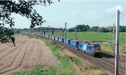  ?? David Clough ?? Tesco already runs a well-establishe­d non-refrigerat­ed container flow between the East Midlands and Scotland. Here, No. 88005 passes Golborne Junction with a Daventry IRFT to Mossend Eurotermin­al service.