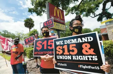  ?? JOHN RAOUX/AP 2021 ?? Workers and family members take part in a 15-city walkout to demand $15 per hour wages in Sanford, Florida.