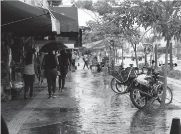  ?? FOTO: EL DEBATE ?? > Ciudadanos resguardán­dose de la lluvia moderada durante una tarde.