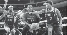  ?? MATT ROURKE AP ?? The Sixers’ Buddy Hield, left, and Kyle Lowry, right, harass Heat center Bam Adebayo on Monday night. He was scoreless in the fourth quarter of the loss.